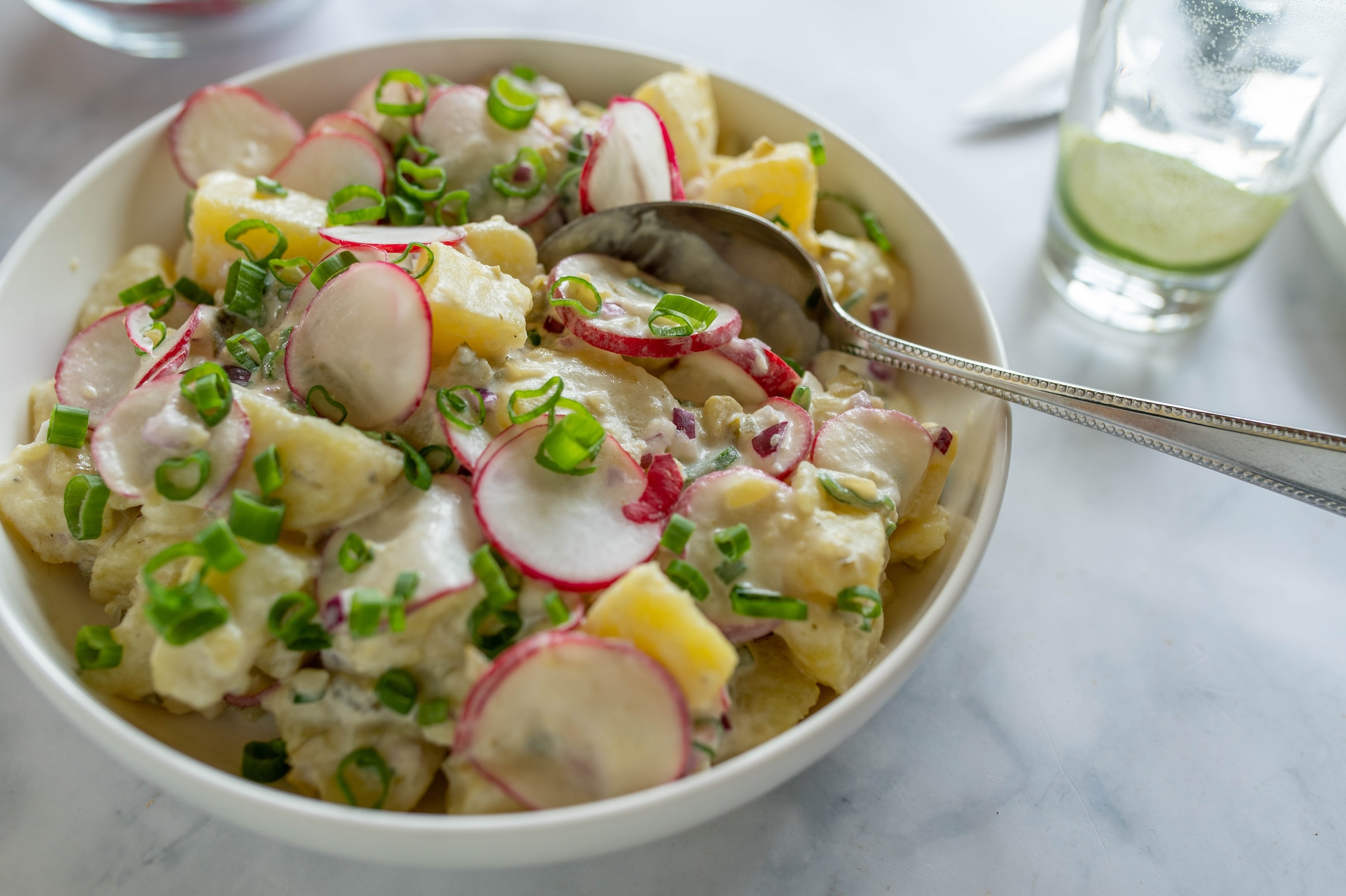 Grekisk, recept, potatissallad, varm, grillning, tillbehör, tzatziki, matlåda, supergod, smakrik, oliver, rödlök, kapris, gräslök, fetaost, tomater, citronsaft. 